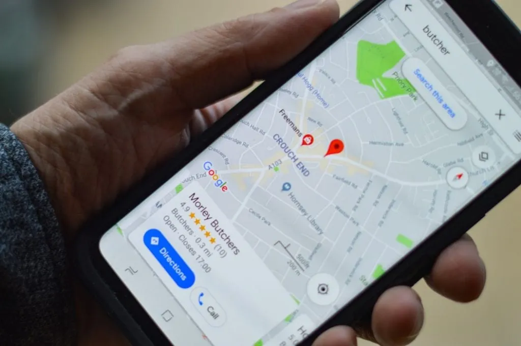 holding a smart phone with google maps showing a business location